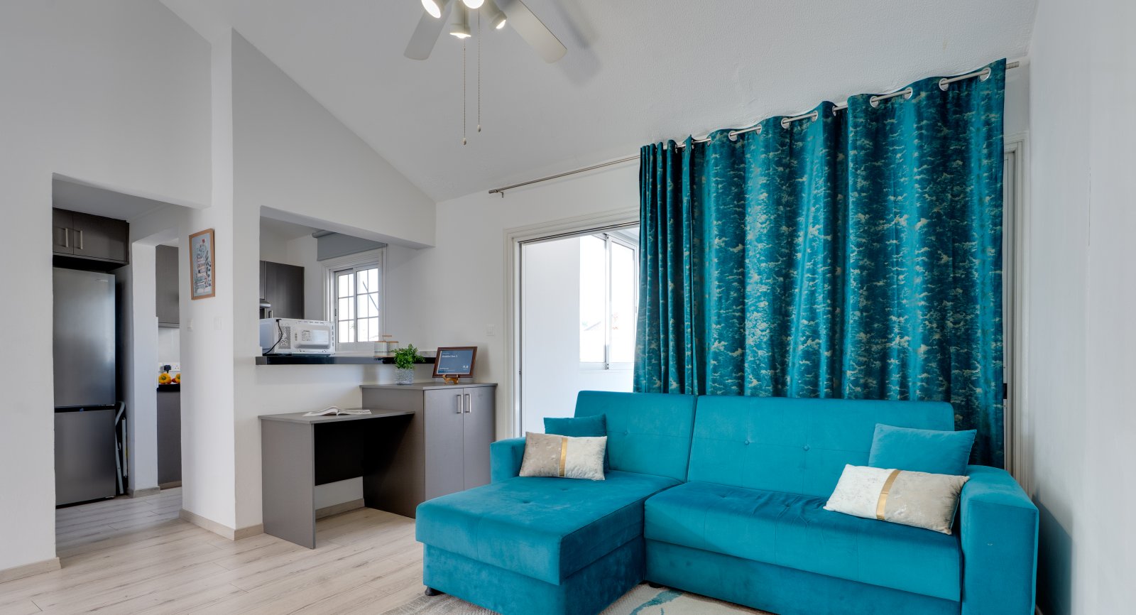 Living room with turquoise corner sofa at the Lux Sandy Beach Suite