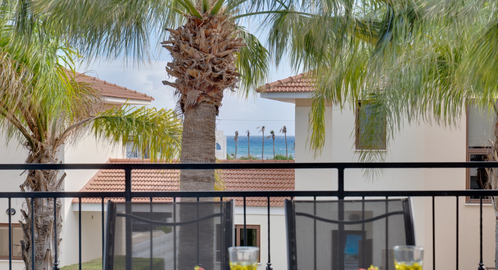 View over the palm garden towards the sea from the Lux Sandy Beach Suite