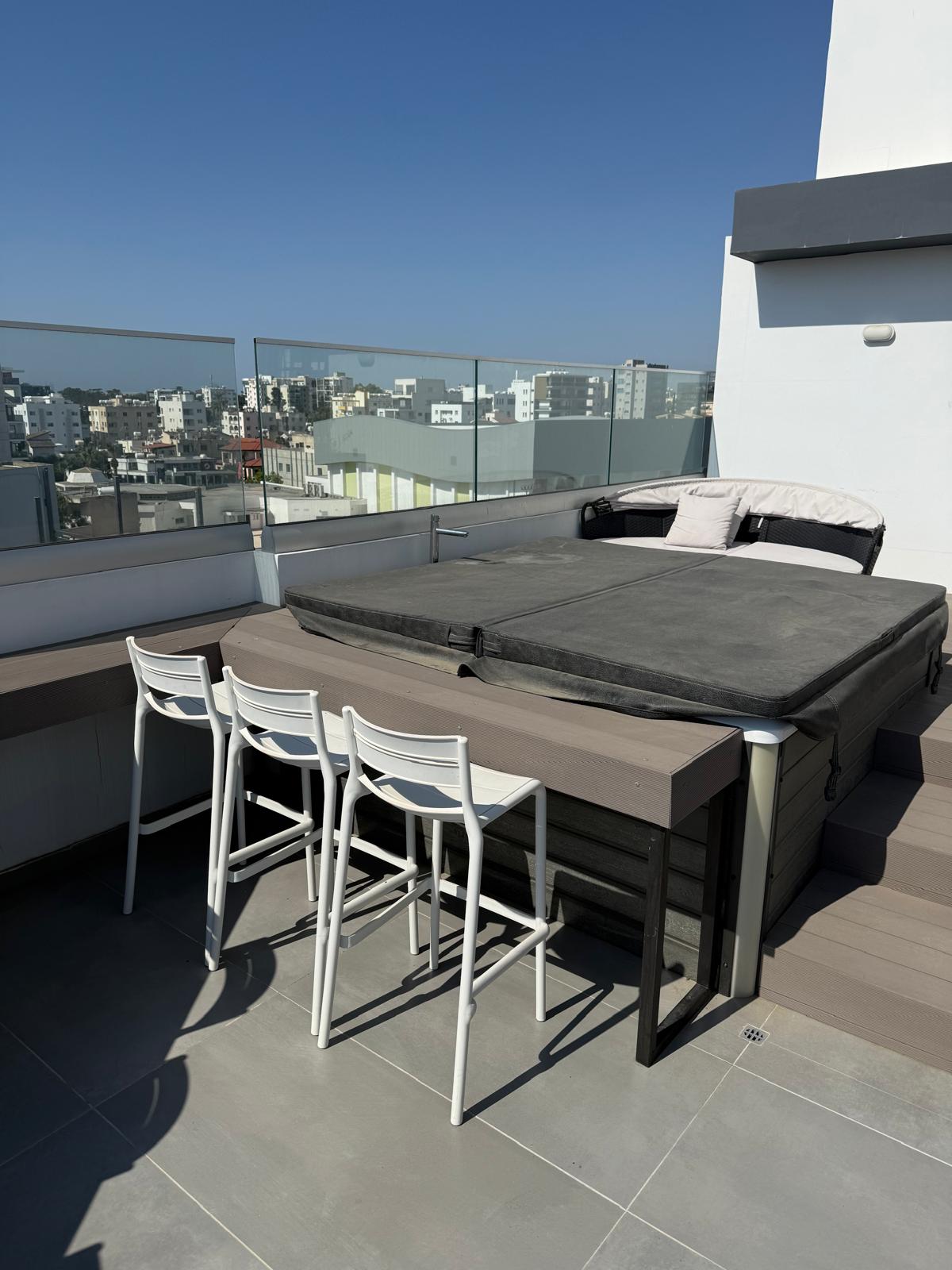 Shared rooftop jacuzzi terrace with city views at the Lux Skyline Suite building